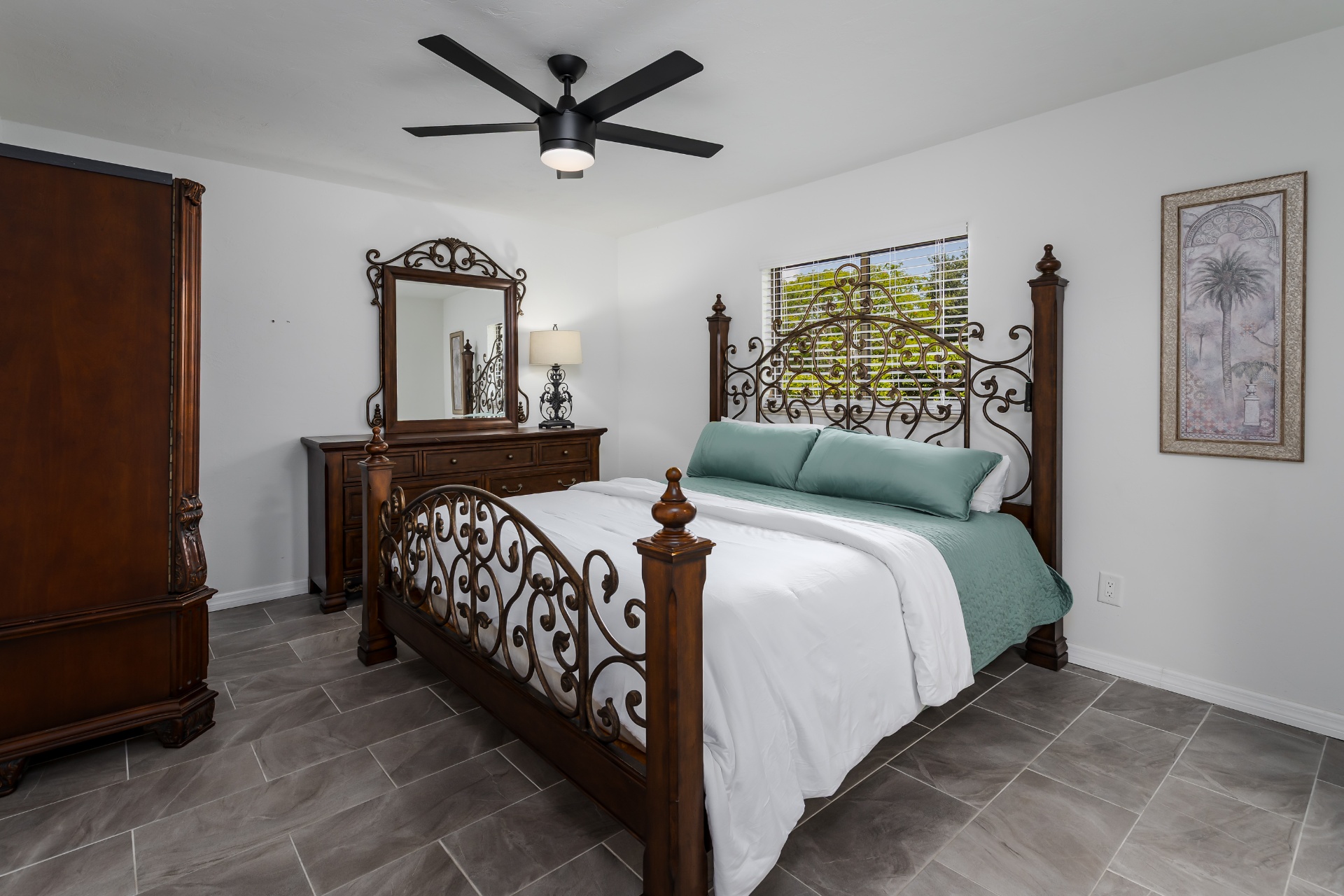 Bedroom with ornate wrought-iron bed and tile floors