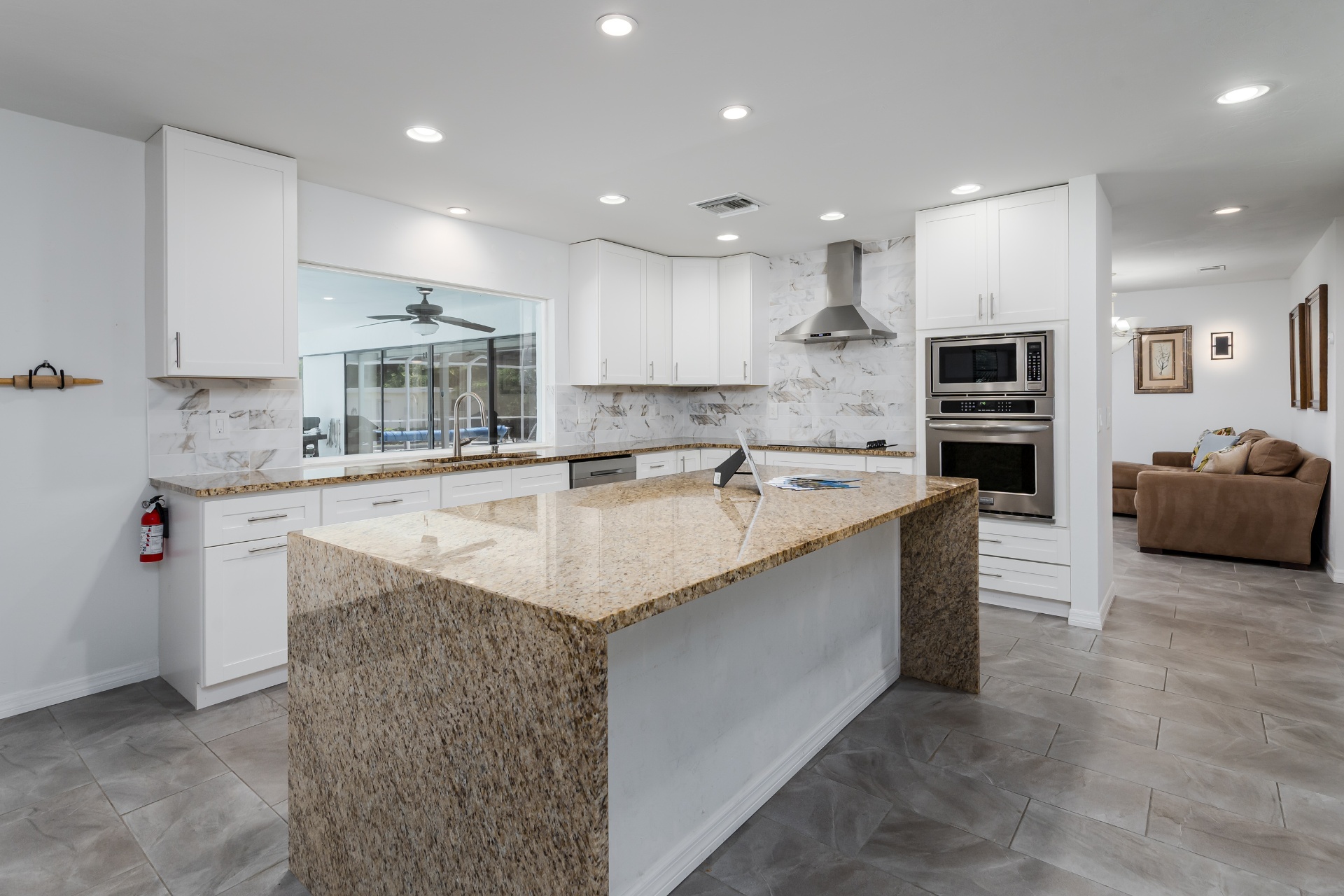 Chef's kitchen with granite island opening to the pool